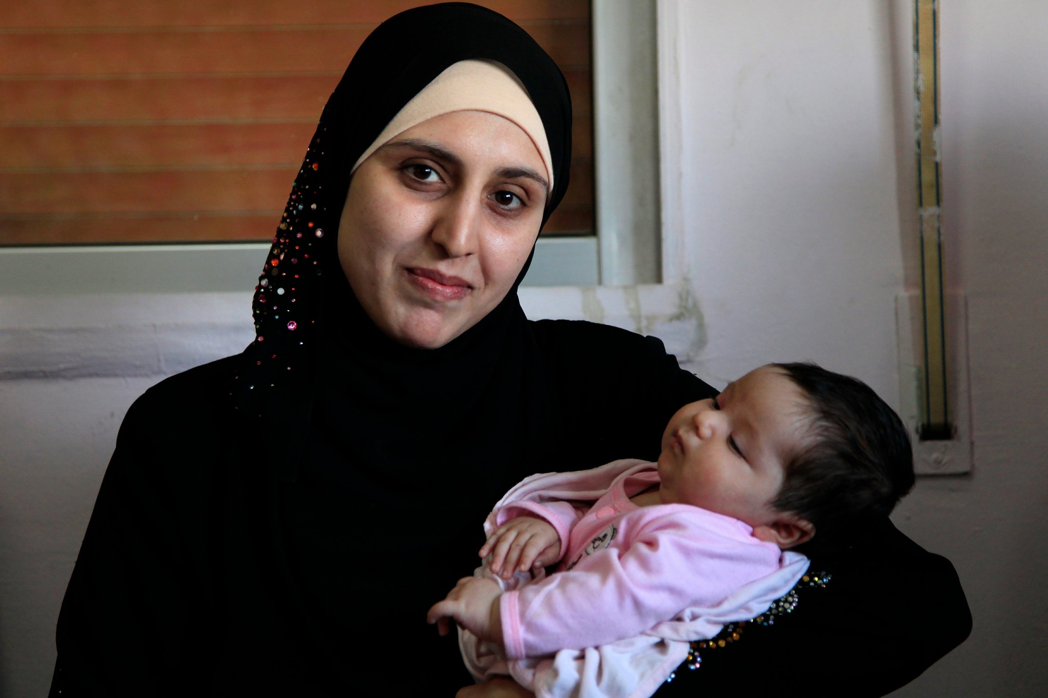 An Afghan refugee woman holding her newborn baby
